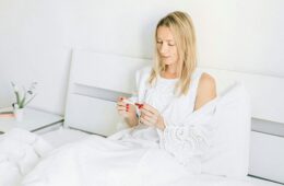 Woman sitting down and viewing a faint line on her pregnancy test.
