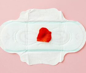 A pad with a rose petal on it representing a woman's first period after having a baby.