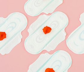 Five pads with rose petals on them representing implantation bleeding.