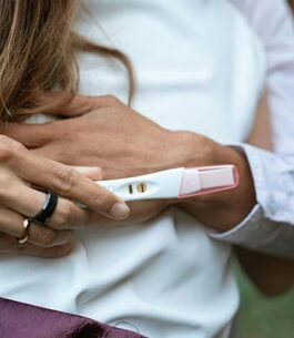 A woman holding an ovulation test as she thinks she's experiencing ovulation pain.