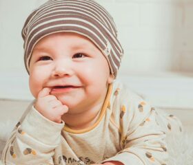 A baby smiling during tummy time.