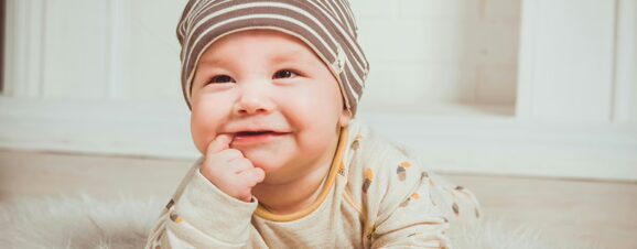 A baby smiling during tummy time.