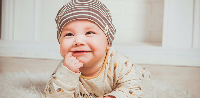 A baby smiling during tummy time.