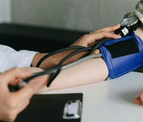 A doctor checking a woman's blood pressure to monitor for preeclampsia.