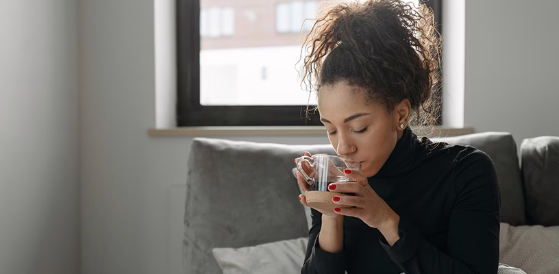 A woman drinking tea as she tries to cope after her miscarriage.