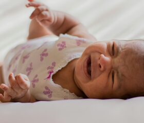 Baby girl lying down and crying during the "witching hour."