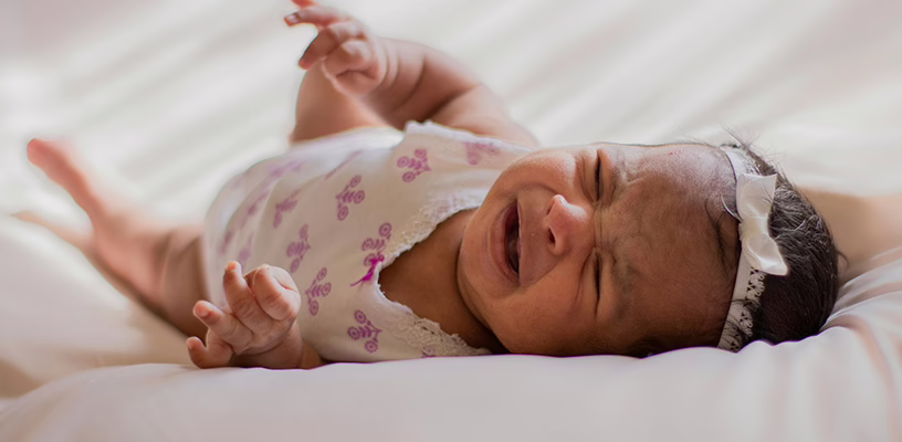 Baby girl lying down and crying during the "witching hour."