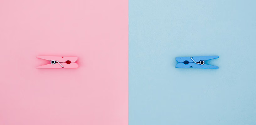 One pink and one blue clothespin, representing a baby girl and baby boy.