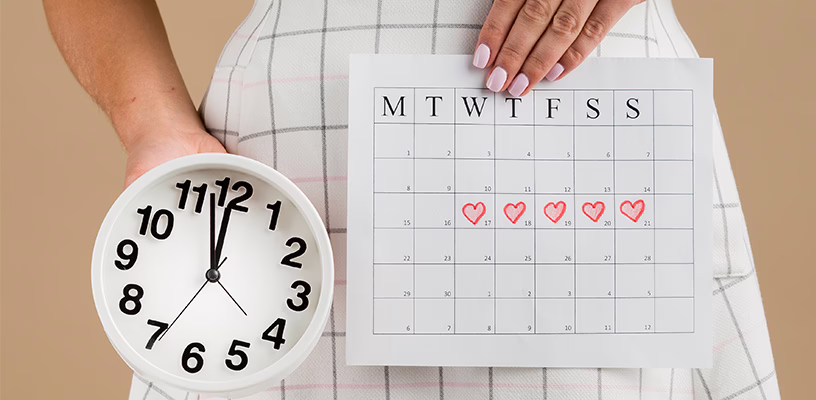 Woman holding a small clock and an ovulation calendar with her fertile window marked.