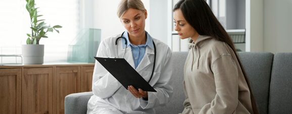 Doctor showing a patient a chart with information on her tubal ligation.