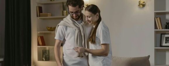 Happy couple examining a positive pregnancy test in the first trimester.
