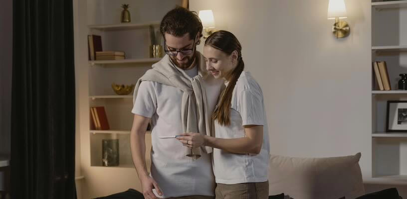 Happy couple examining a positive pregnancy test in the first trimester.