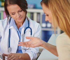 Doctor presenting a woman with the results of her AFC test.