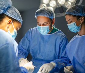 Room of surgeons performing a C-section on a soon-to-be mother.