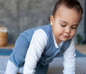 A 10-month-old baby crawling on the floor.