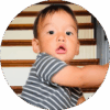 11-month-old baby sitting at the bottom of the stairs.