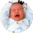 Fussy two-month-old baby lying in crib, crying, and raising arms.