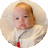 Swaddled three-month-old baby propped up against pillow.
