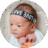 Three-week-old baby lying on pillow and looking sideways while playing with his fingers.