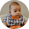 Four-month-old baby dressed in checkered shirt with bow tie.