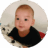 Smiling five-month-old baby pushing himself up on pillows.