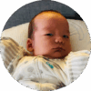 Swaddled six-week-old baby lying on pillow.