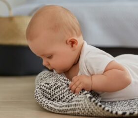 A 6-week-old baby holding his head up during tummy time.