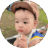 9-month-old baby sitting outside in park and wearing hat to protect from sun.