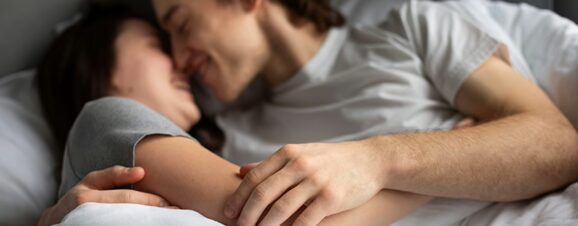 Couple snuggling together in bed.