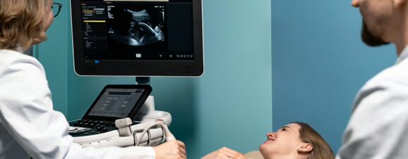 Woman in a doctor's office looking at her baby's first ultrasound.