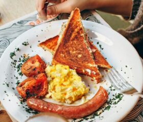 Plate of a pregnant woman who is craving eggs, sausage, tomatoes, and toast.