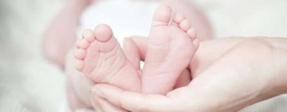Close-up of a newborn baby's feet (representing the feet-first breech position).