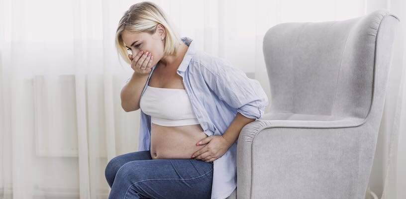 Pregnant woman holding her mouth as if about to vomit, due to her heightened sense of smell.