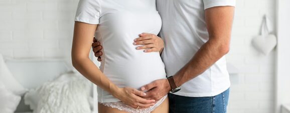 Pregnant couple embracing after successful IUI treatment.