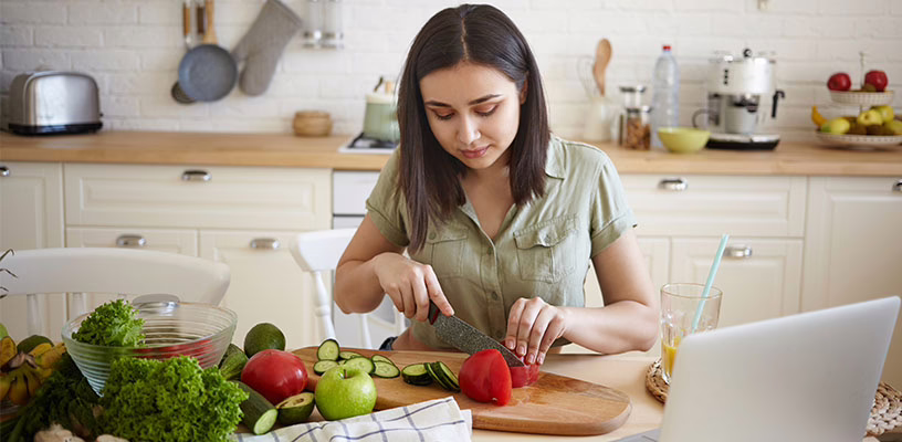 Woman preparing fruits and veggies as part of her fertility diet.