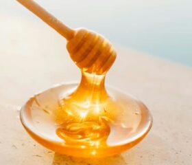 Honey dipper and a small bowl of honey, representing the fact that babies can't eat honey before they're 1.