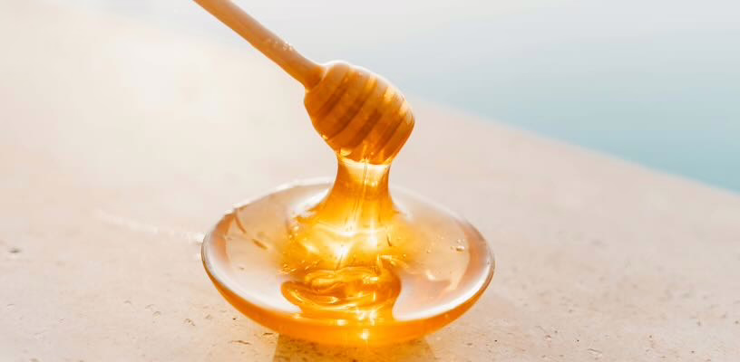 Honey dipper and a small bowl of honey, representing the fact that babies can't eat honey before they're 1.