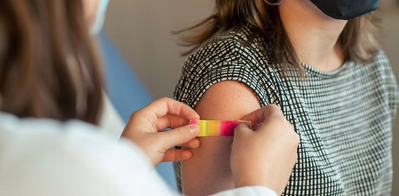 Pregnant woman getting a bandage placed over her flu shot injection site.