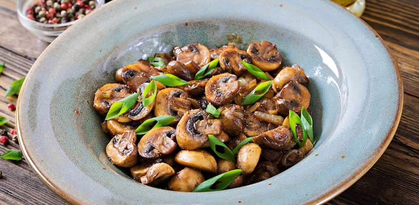 Bowl of cooked mushrooms, which would be safe for pregnant women to eat.