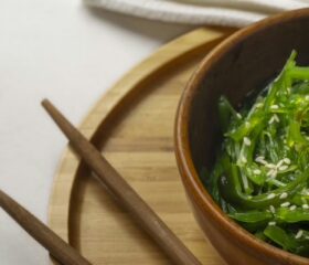 A bowl of green seaweed, which is a suitable food for pregnancy.