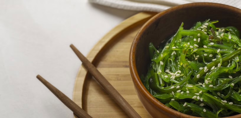 A bowl of green seaweed, which is a suitable food for pregnancy.
