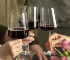 Three people holding glasses of wine, symbolizing that you can't drink wine or alcohol when pregnant.