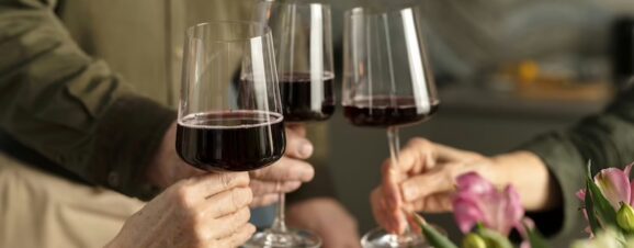 Three people holding glasses of wine, symbolizing that you can't drink wine or alcohol when pregnant.