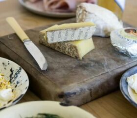 Selection of cheeses on a cutting board, symbolizing that certain kinds of cheese are unsafe during pregnancy.