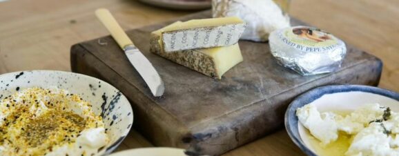 Selection of cheeses on a cutting board, symbolizing that certain kinds of cheese are unsafe during pregnancy.