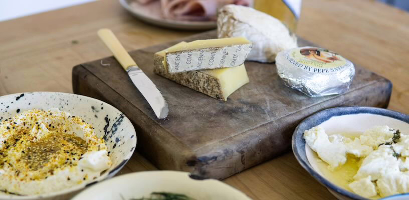 Selection of cheeses on a cutting board, symbolizing that certain kinds of cheese are unsafe during pregnancy.