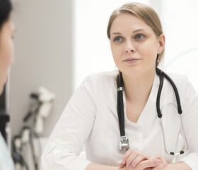 Woman talking with doctor at her first pregnancy appointment.