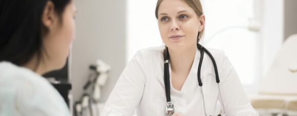 Woman talking with doctor at her first pregnancy appointment.