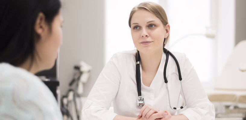 Woman talking with doctor at her first pregnancy appointment.