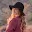 Woman wearing a black hat looking over her shoulders at the camera.